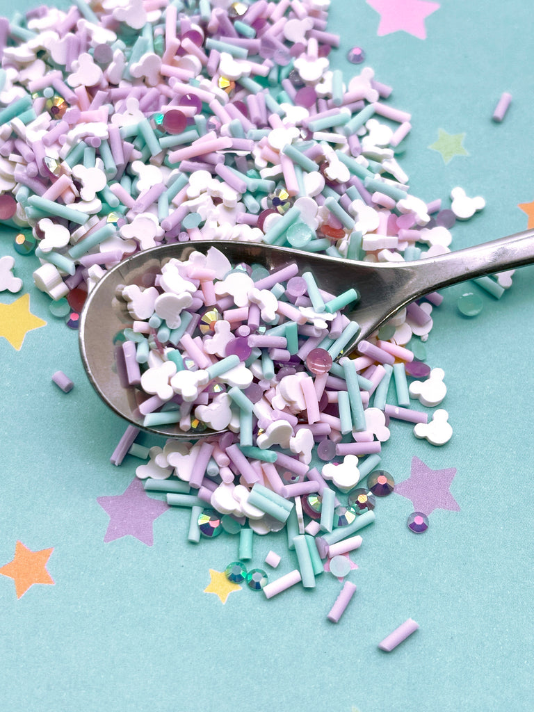 a spoon filled with sprinkles on top of a table