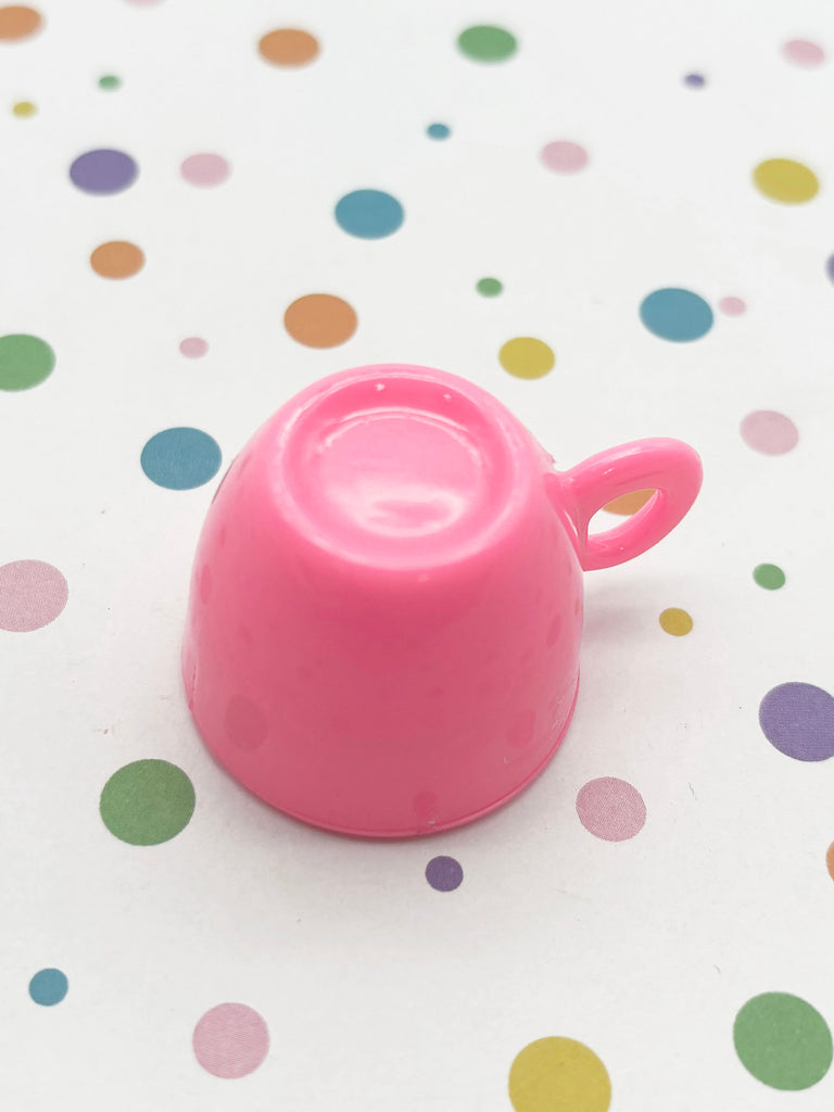 a pink tea pot sitting on top of a table