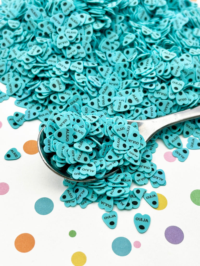 a spoon full of blue buttons sitting on top of a table