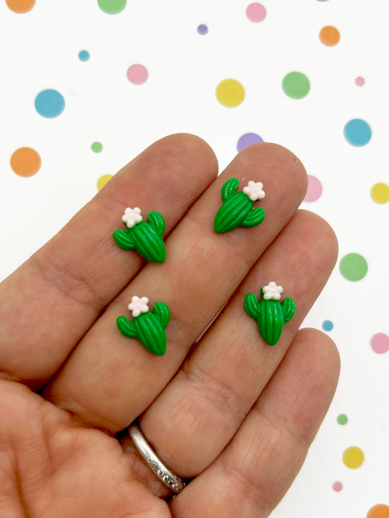 a hand holding three small green and white flowers