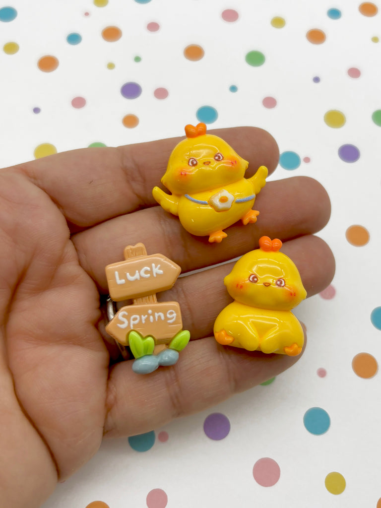 a hand holding three tiny yellow rubber ducks