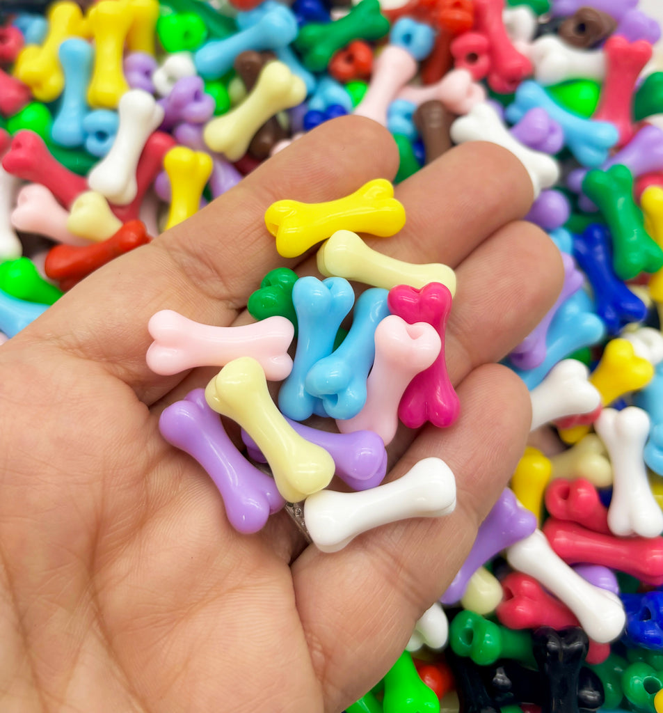 a hand holding a pile of colorful dog bones and bones