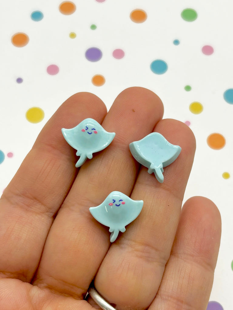 a person is holding two tiny blue birds