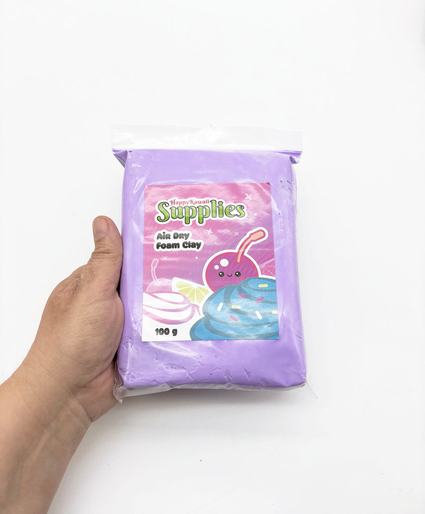 A hand is holding a package of purple foam clay, which is labeled as a "Happy Kawaii Supplies" product.