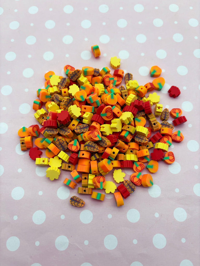 A pile of colorful, multicolored beads or buttons on a polka dot background.