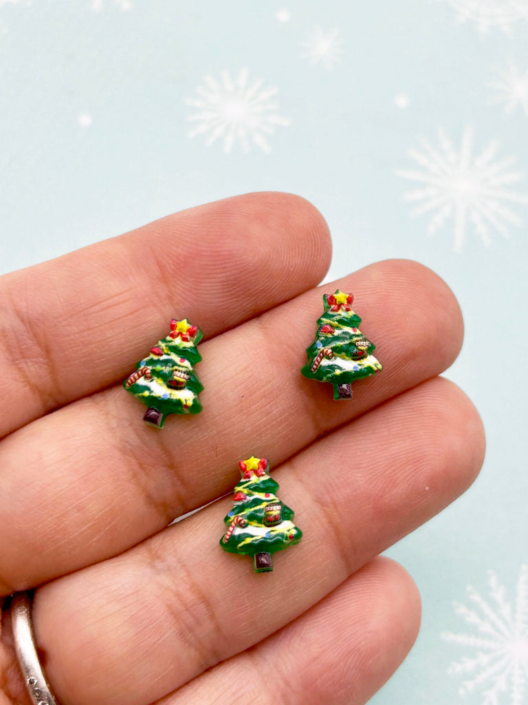 a person is holding three tiny christmas trees