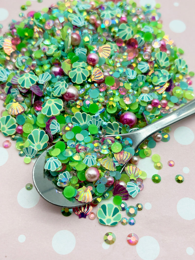 a spoon filled with lots of green and purple beads