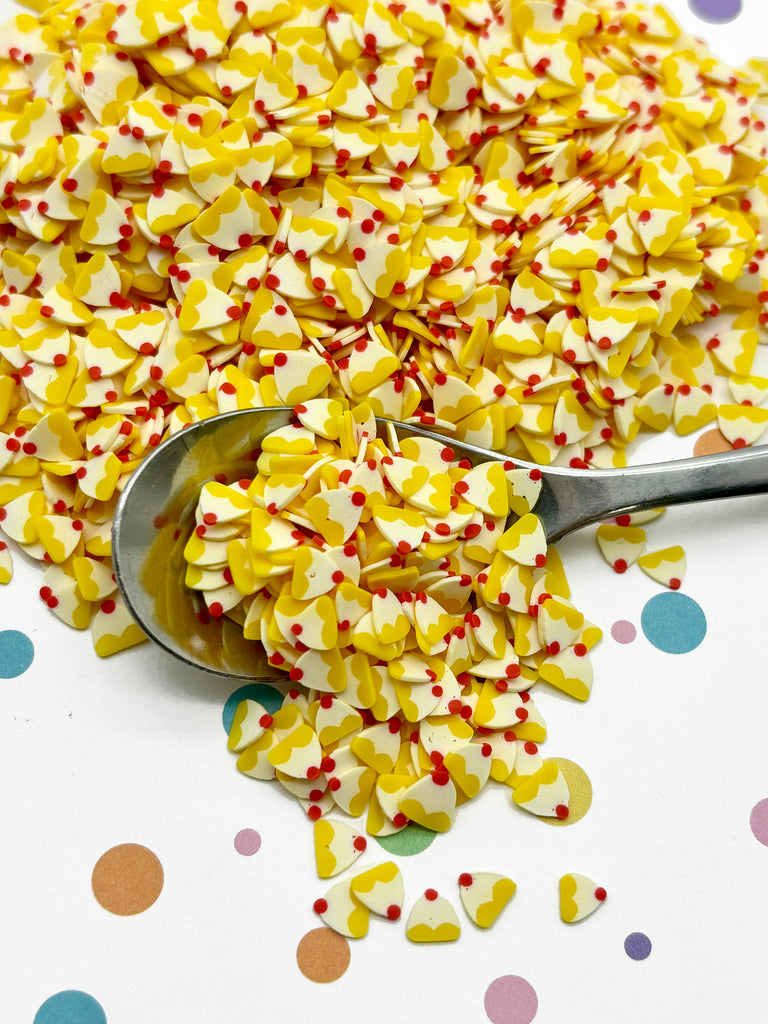 a spoon filled with yellow and red confetti