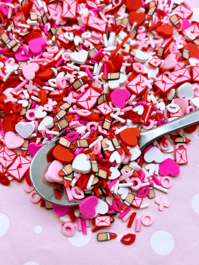 a spoon full of pink and red heart shaped confetti
