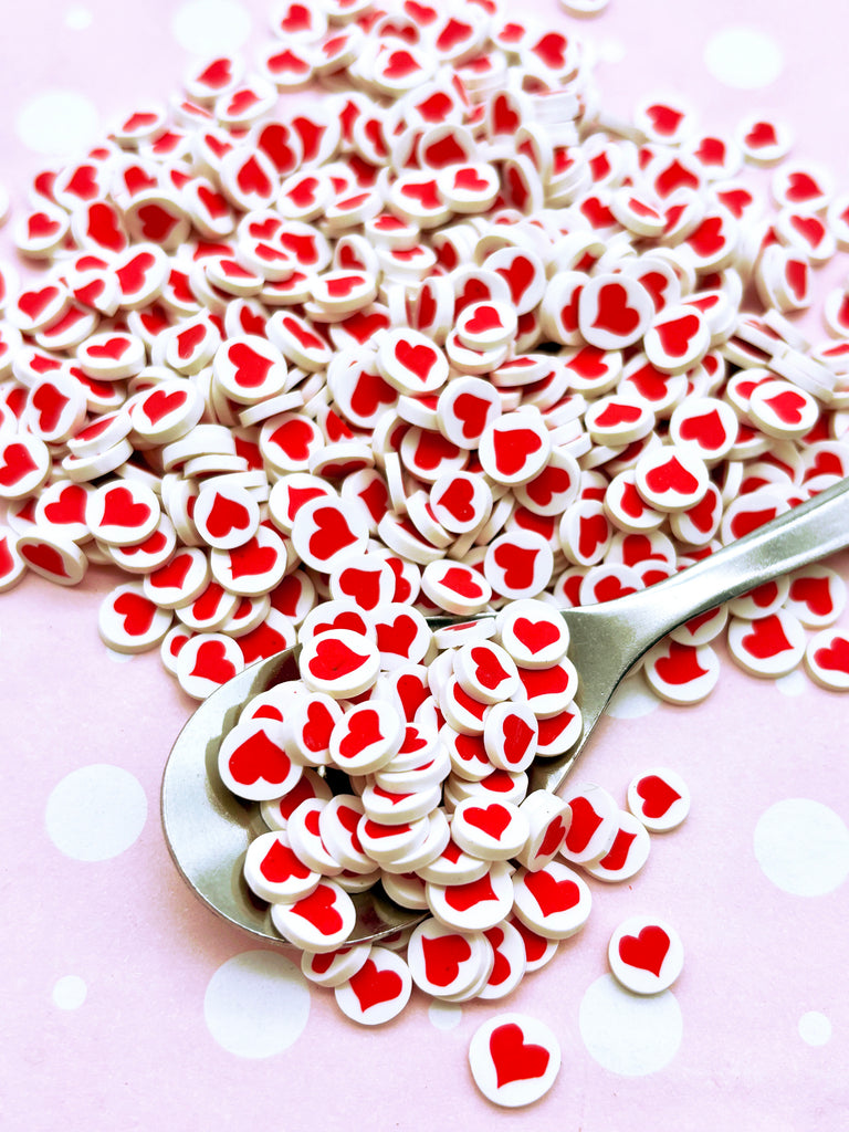 a spoon filled with red and white hearts