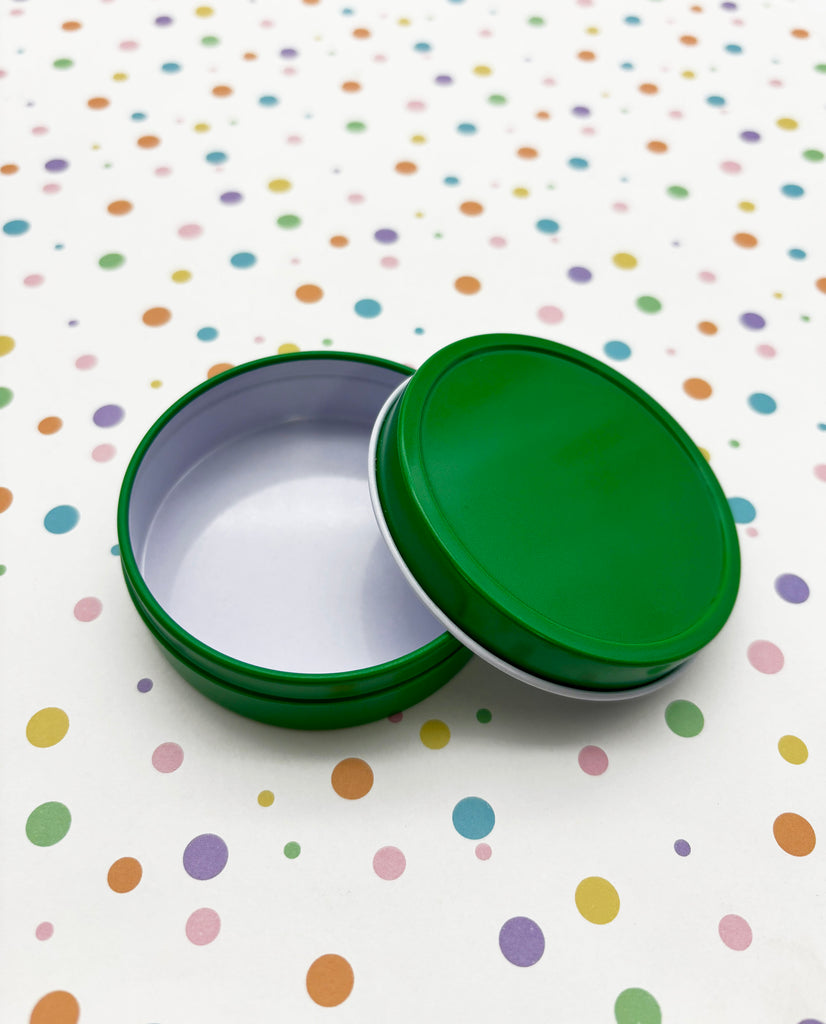 two green and white tins sitting on a polka dot tablecloth