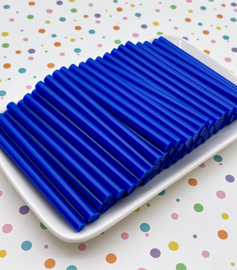 A white plate holding numerous blue plastic straws arranged in a row.