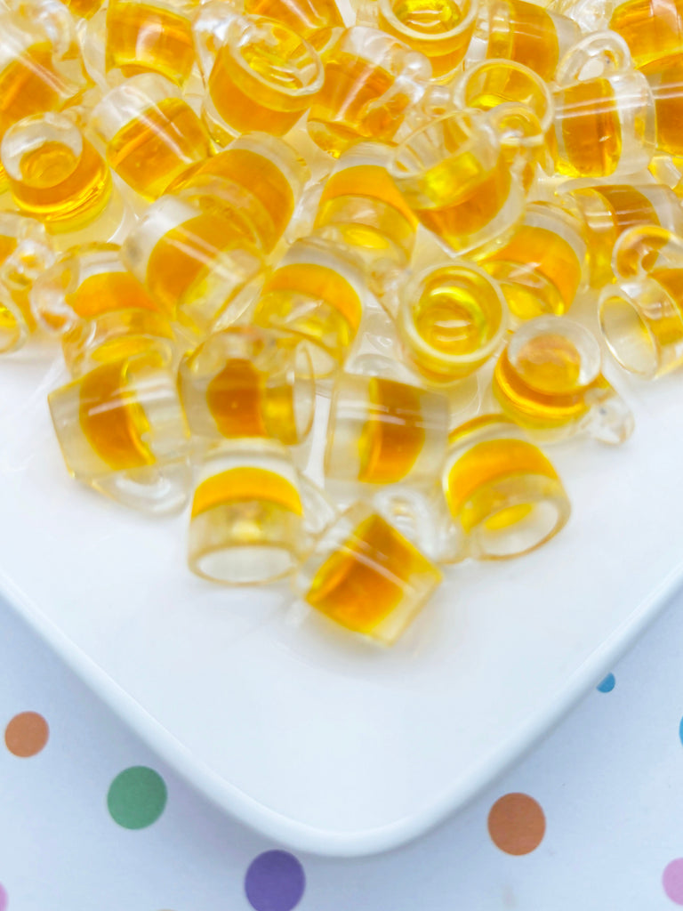 a white plate topped with lots of yellow beads