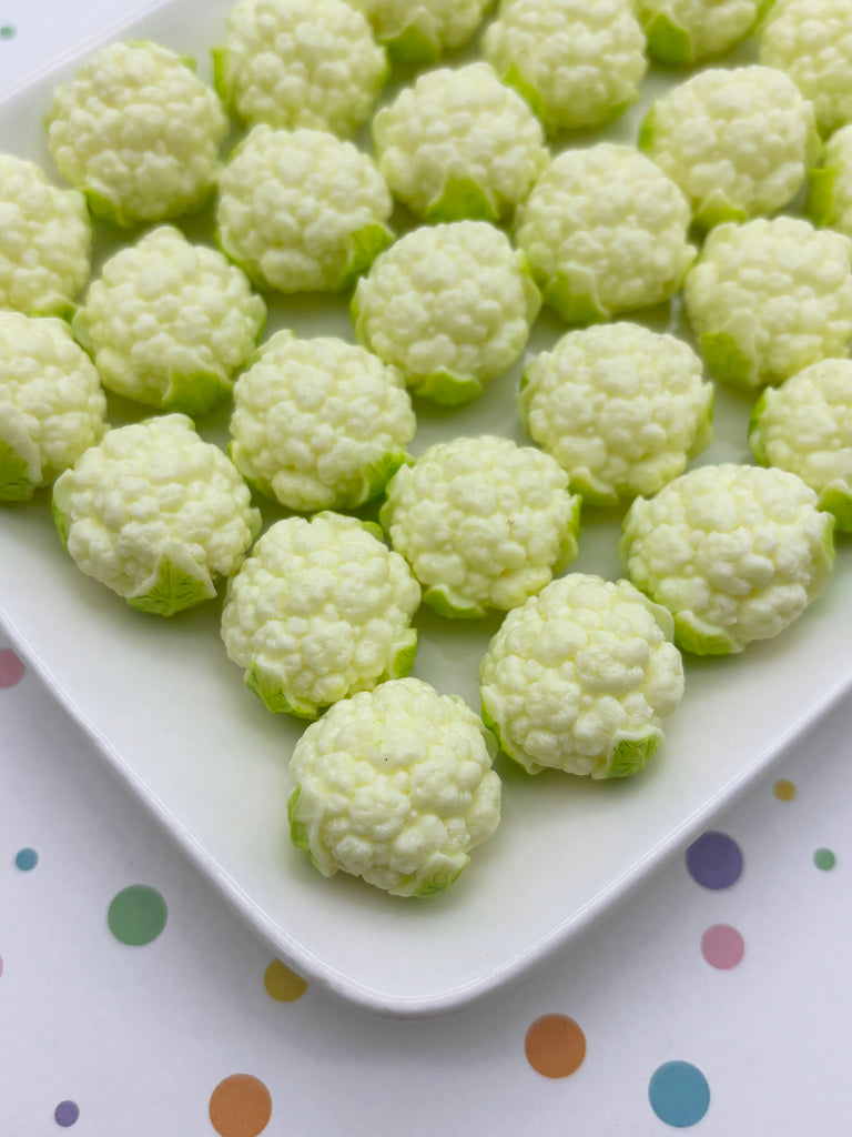 A white plate filled with small, white cauliflower balls arranged in a pattern.