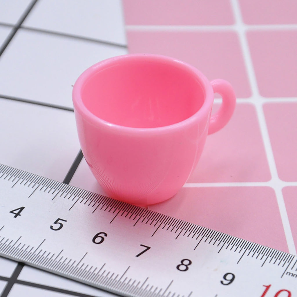 a pink cup sitting on top of a ruler