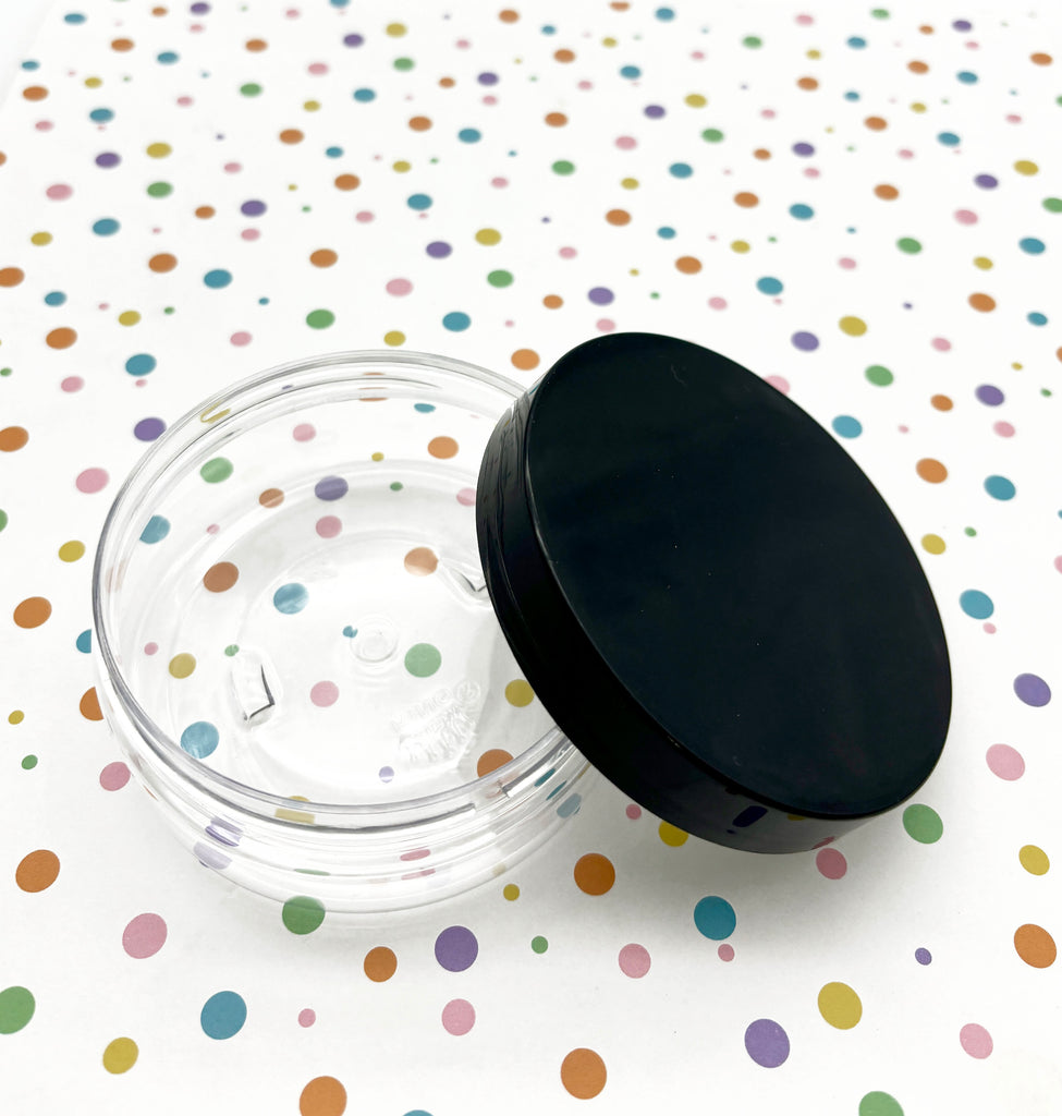 a black lid on a clear container on a polka dot tablecloth