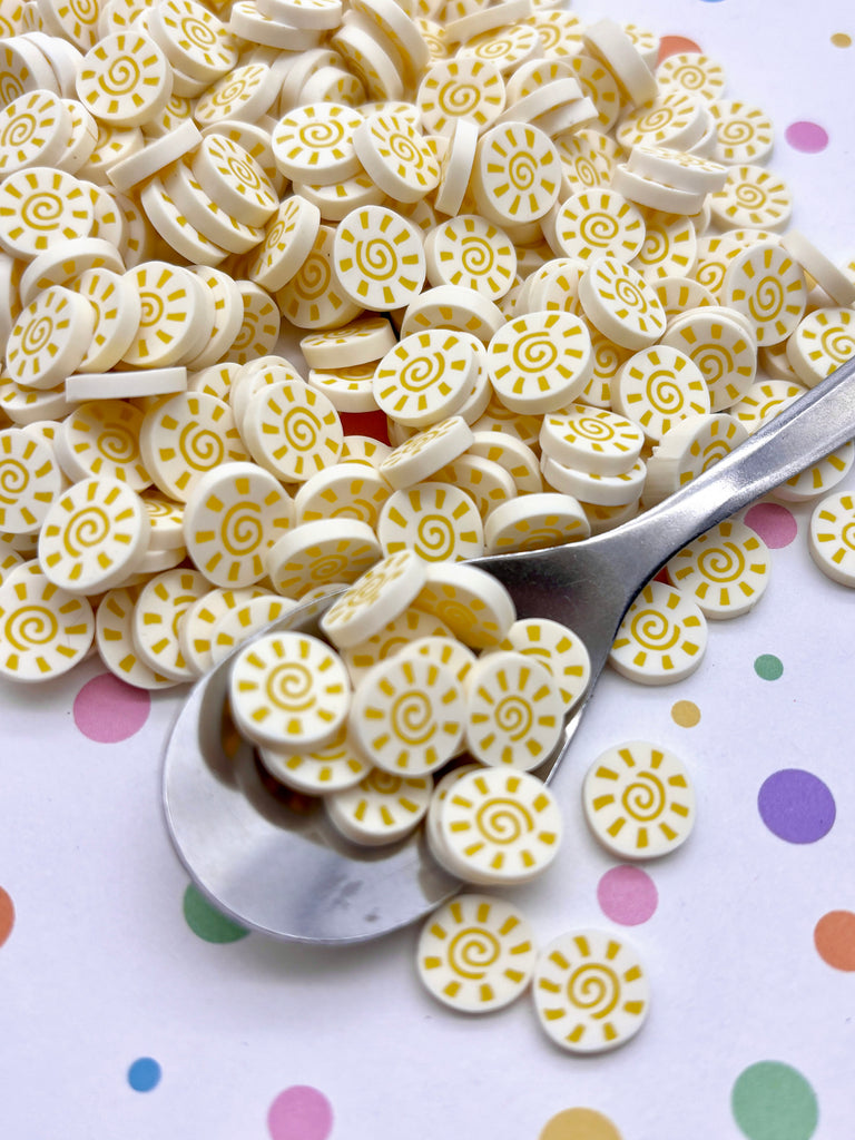 a spoon full of yellow and white buttons