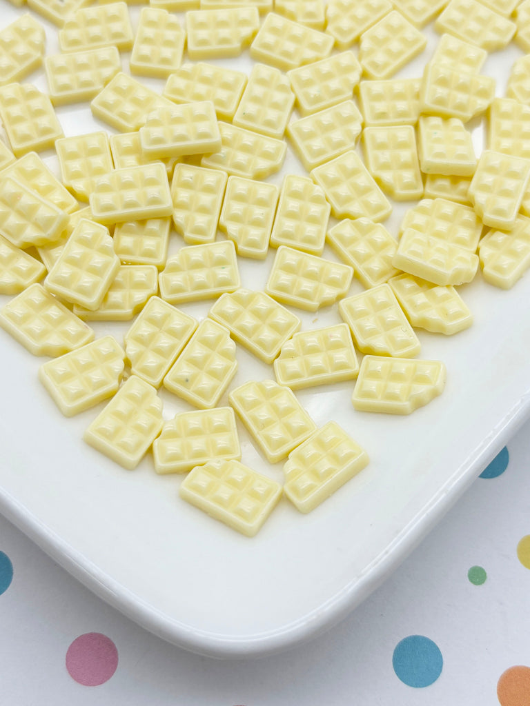 a white plate topped with yellow waffles on top of a polka dot table