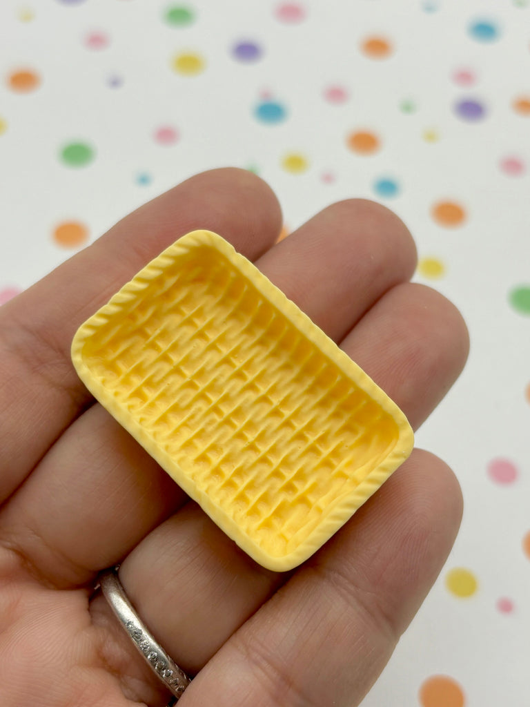 a person holding a tiny yellow object in their hand