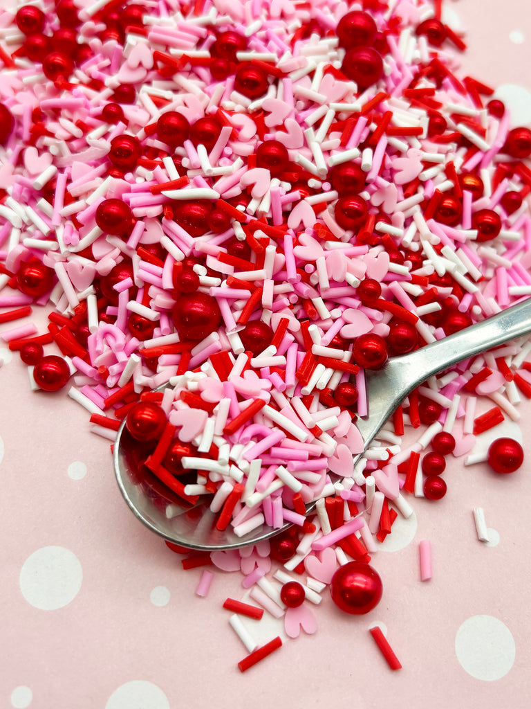 a spoon full of sprinkles sitting on top of a table