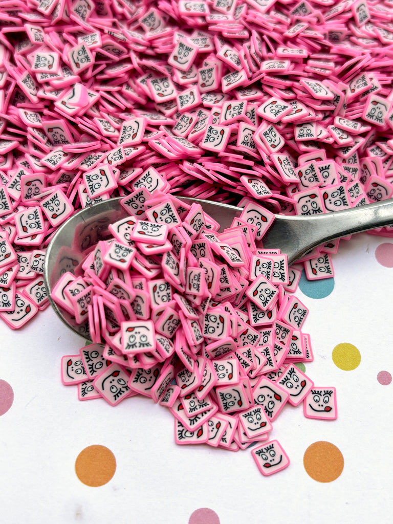 a spoon full of pink and black buttons