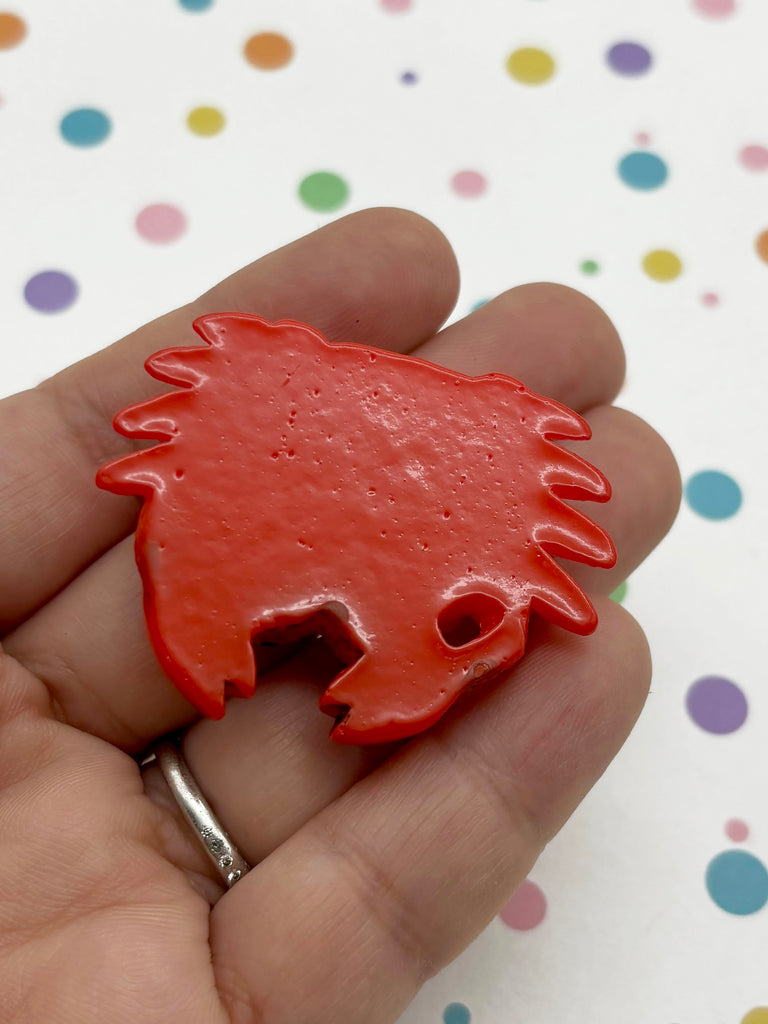 a person is holding a red object in their hand