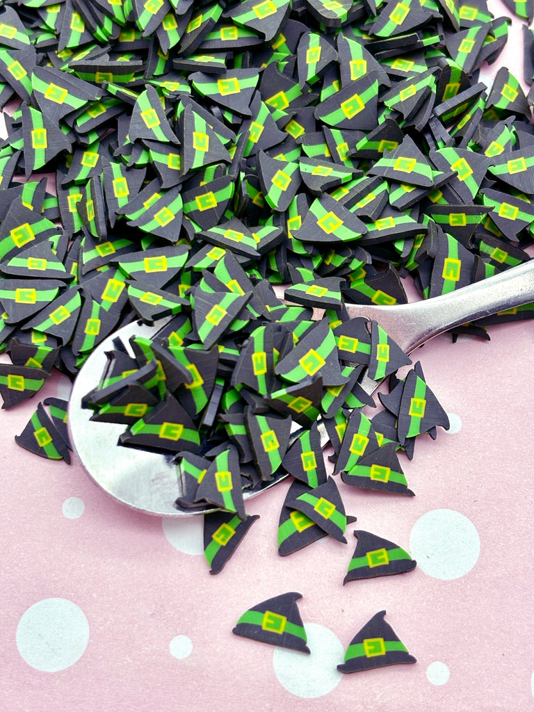 a spoon full of black and green paper triangles