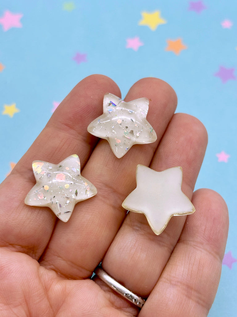 a person is holding three small stars in their hand