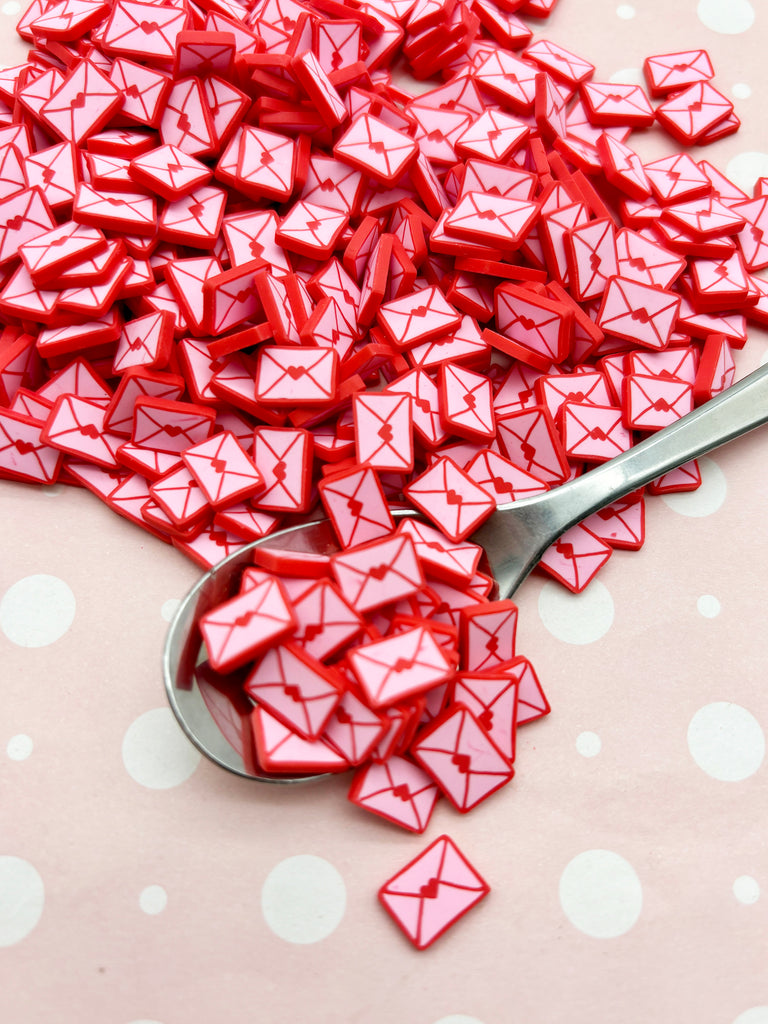 a spoon full of red origami pieces