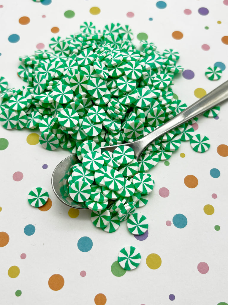 a spoon and a pile of green and white candies