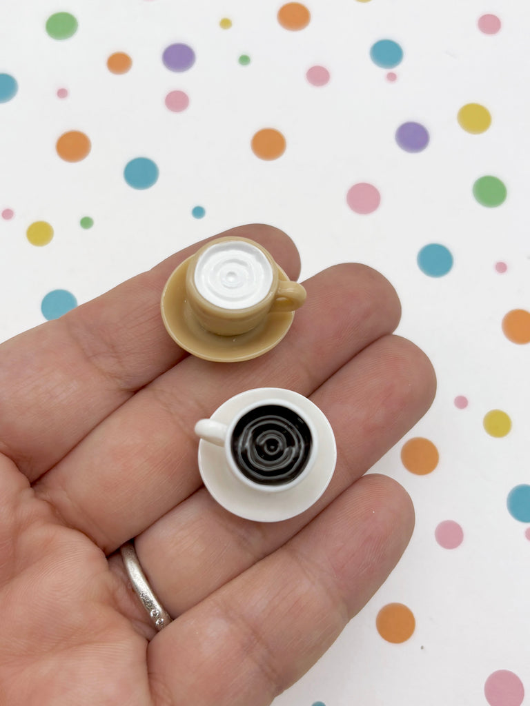 A hand holding two small coffee cups against a background with colorful polka dots.