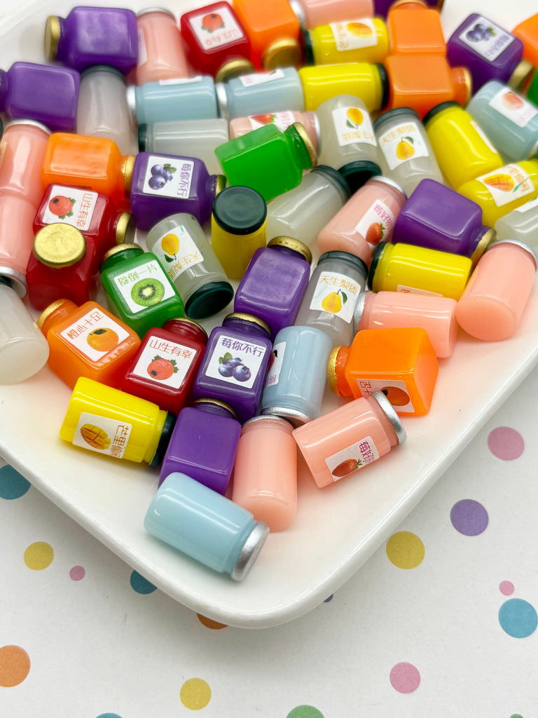 a variety of colorful plastic containers and jars, some of which appear to be juice bottles, placed on a white surface with a polka dot pattern.
