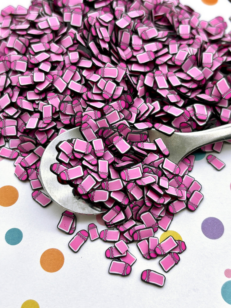 a spoon full of pink squares on a polka dot tablecloth