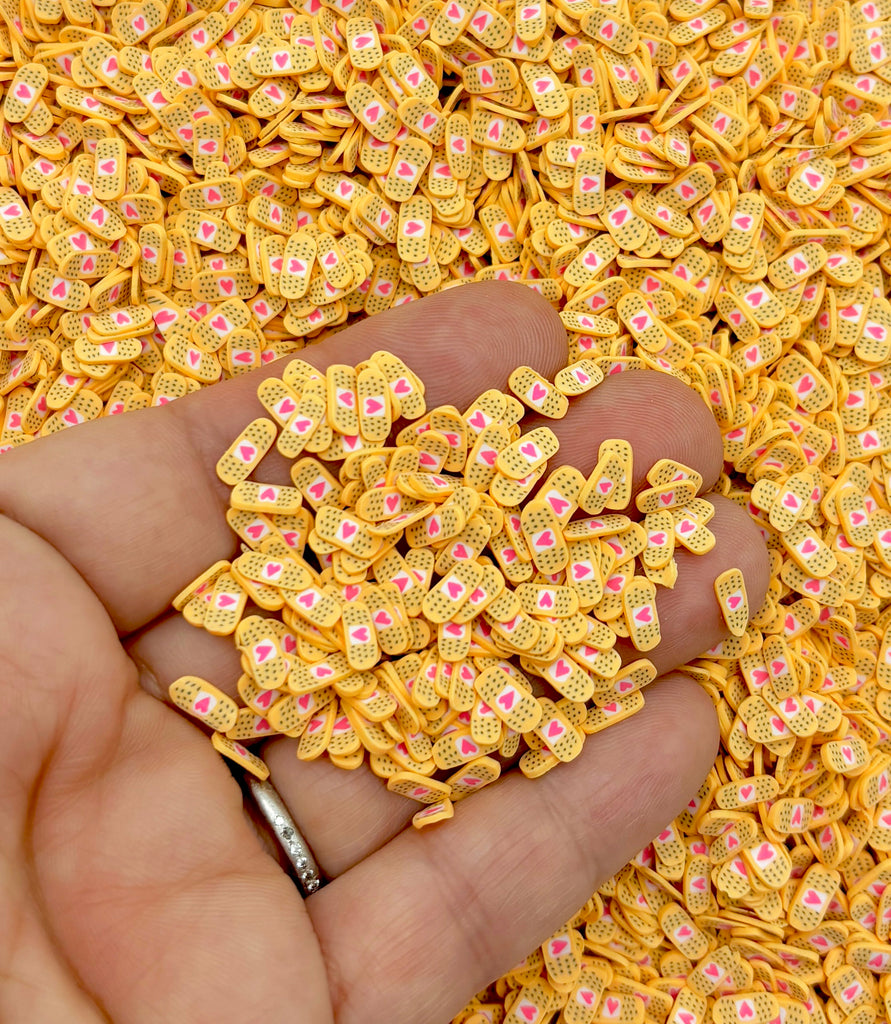 a hand holding a pile of gold colored beads