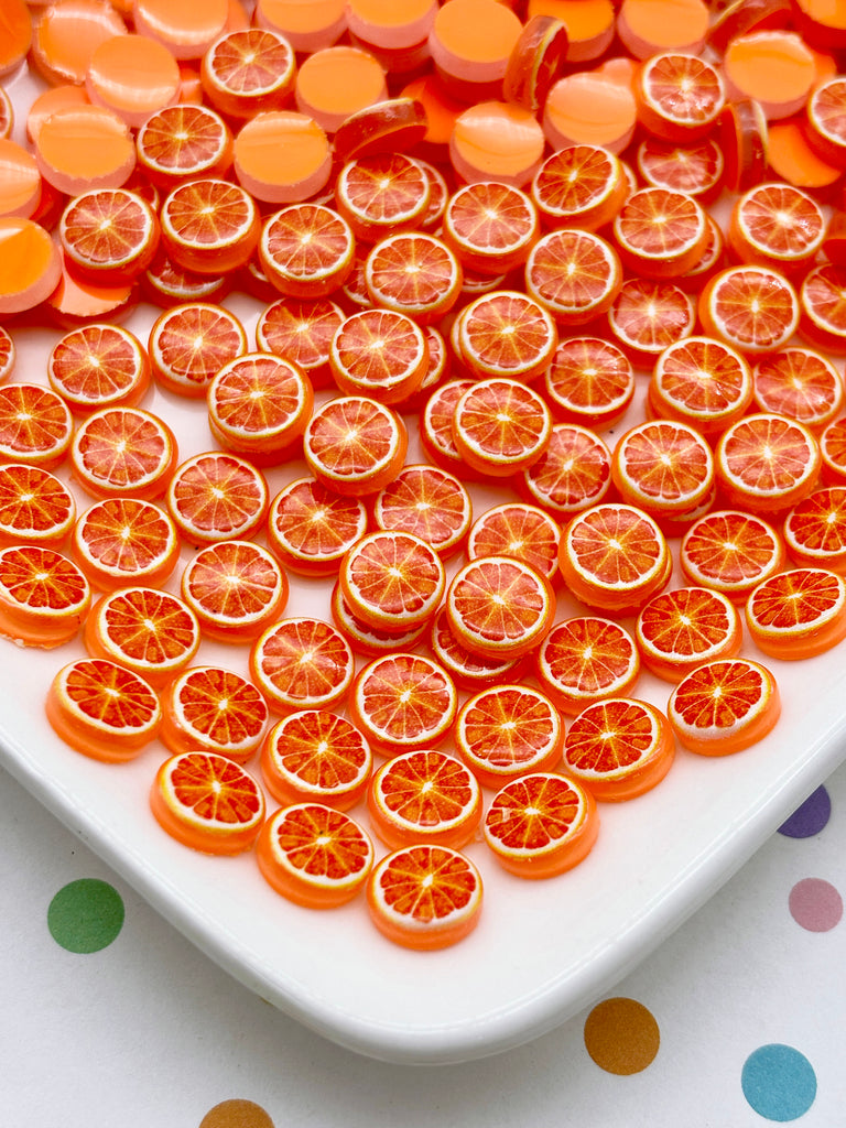 a white plate with numerous orange-colored plastic pieces arranged in a visually appealing pattern.