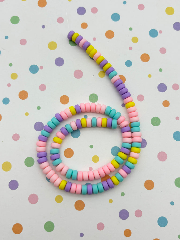 a multicolored beaded necklace on a polka dot background