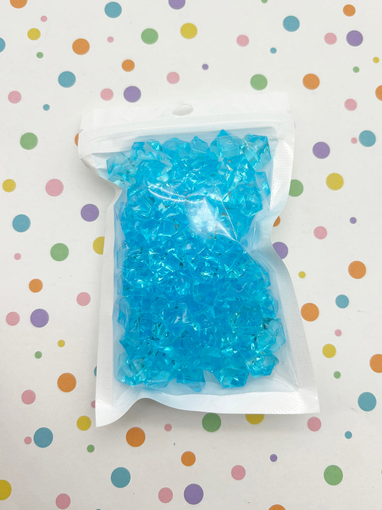 a bag of blue beads sitting on top of a table