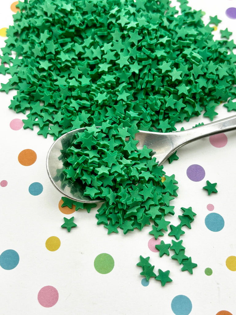 a spoon filled with green sprinkles on top of a table