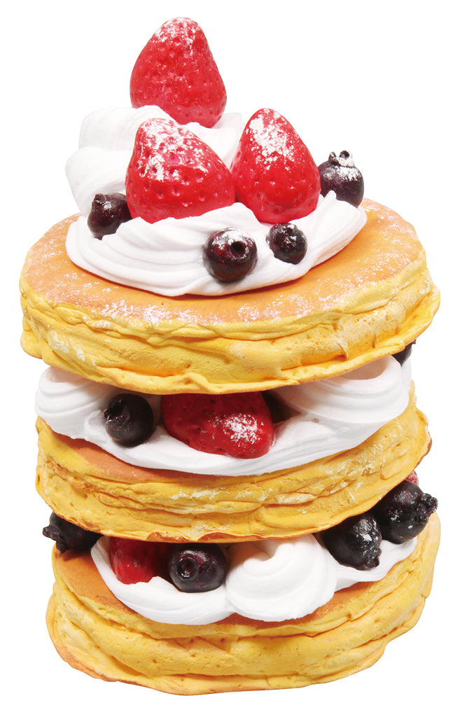 a stack of pancakes topped with whipped cream and berries