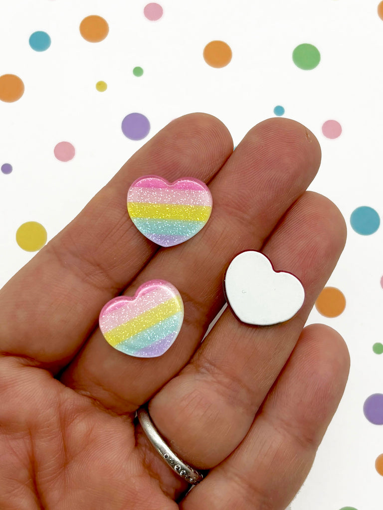 a person holding two heart shaped magnets in their hand