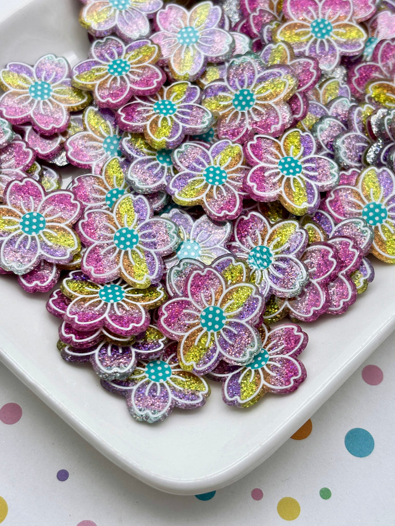 a white plate filled with multicolored, glittery flower-shaped objects.