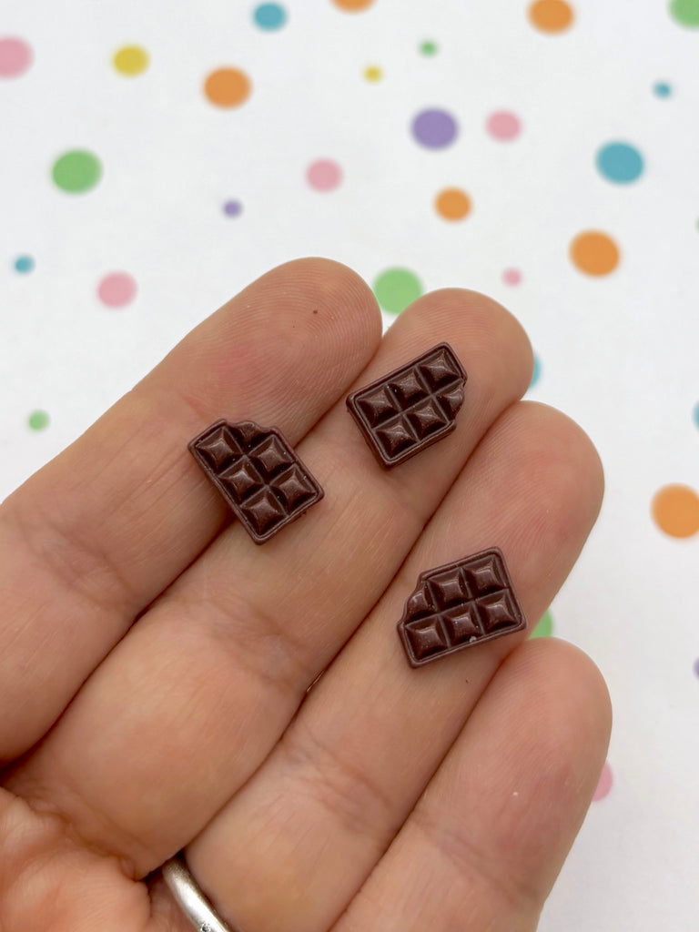 a person holding two pieces of chocolate in their hand