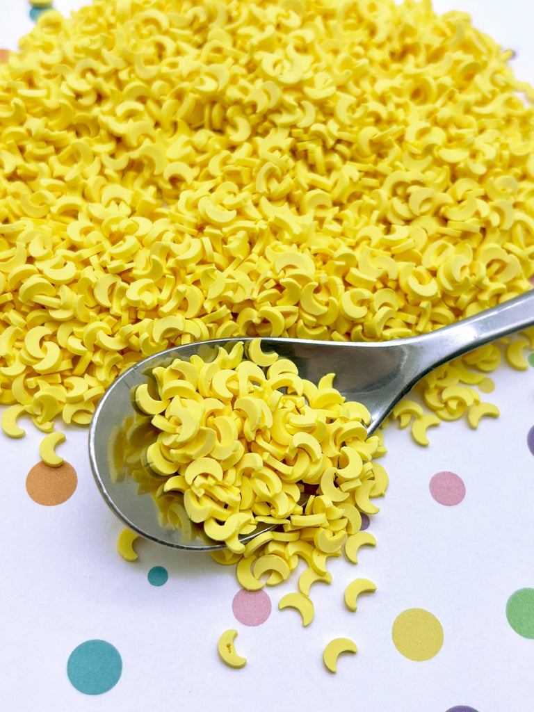 a spoon full of yellow noodles on a polka dot tablecloth