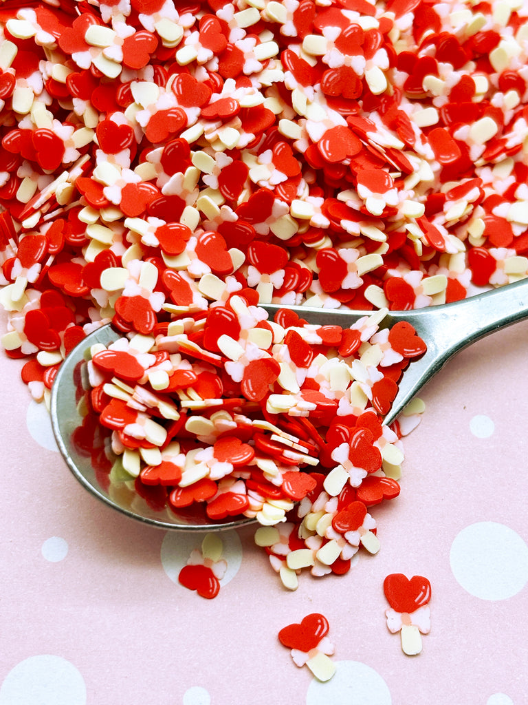 a spoon full of red and white sprinkles
