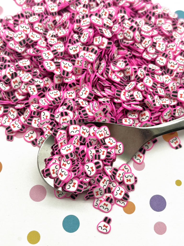 a spoon full of pink sprinkles sitting on top of a polka dot