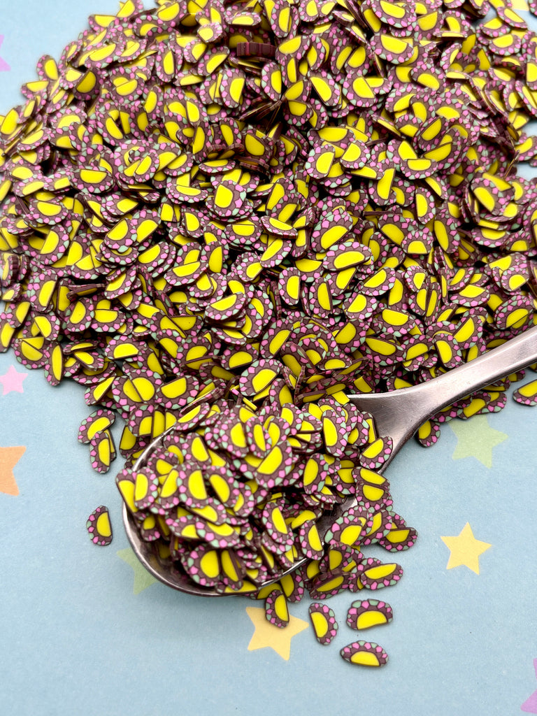 a spoon full of purple and yellow sprinkles