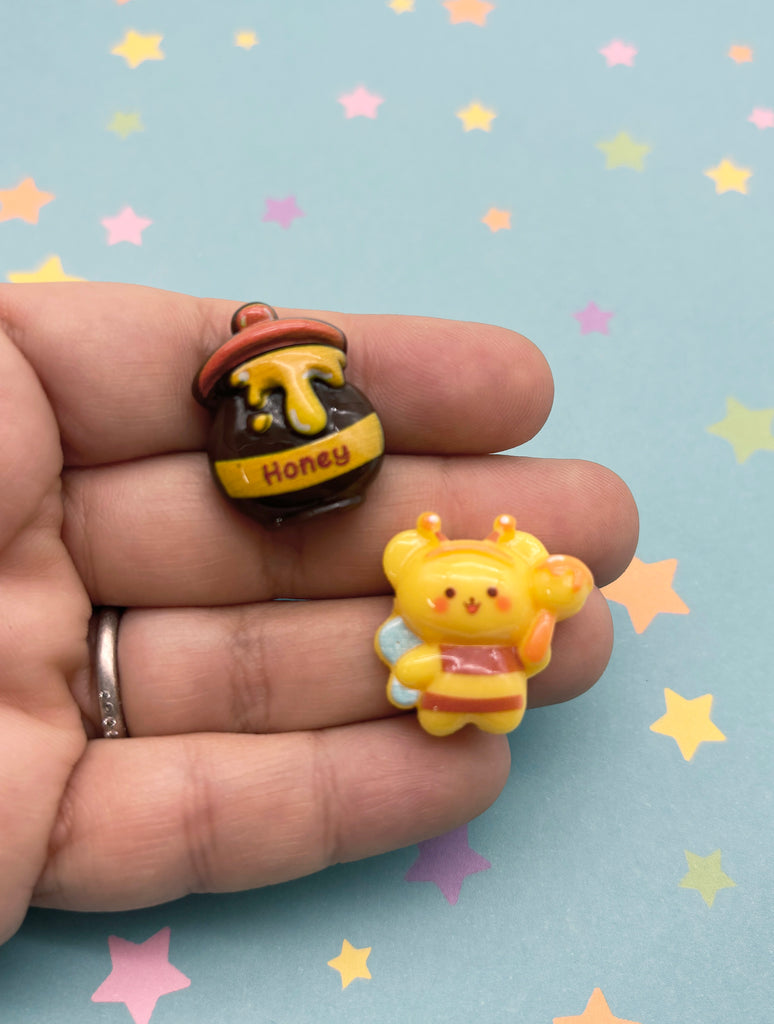 a hand holding a tiny yellow and brown bear