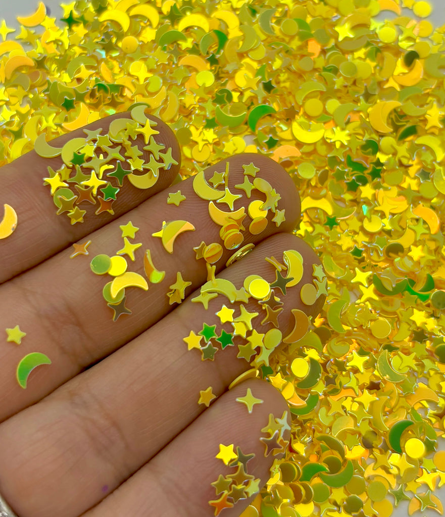 a hand holding a pile of gold glitter stars