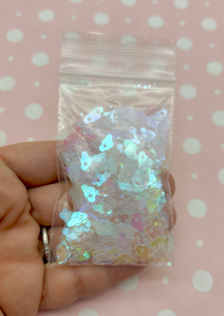 a hand holding a bag of white and silver confetti