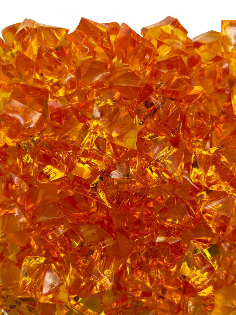 a close up of a pile of orange glass